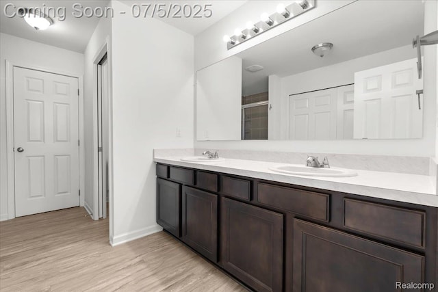 21422 Navarra Dr, South Lyon, MI 48178 - full bathroom with double vanity, a shower with shower door, and wood finished floors