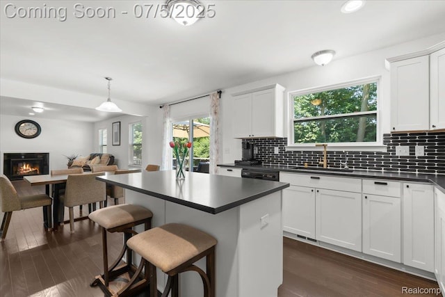 21422 Navarra Dr, South Lyon, MI 48178 - kitchen featuring dark countertops, a glass covered fireplace, a breakfast bar, backsplash, and recessed lighting