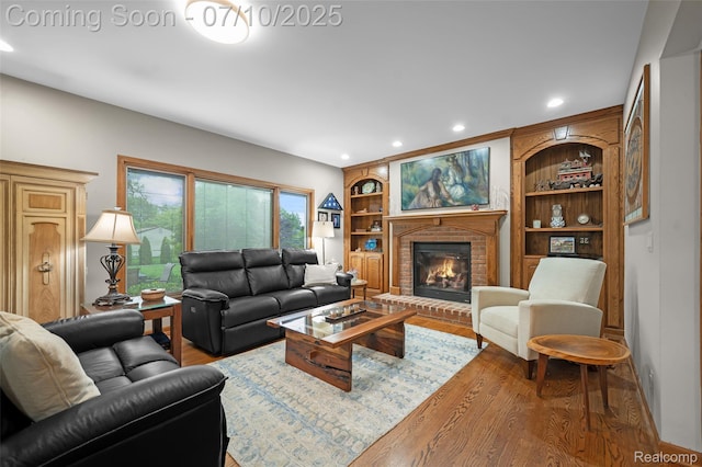 1304 Midland Blvd, Royal Oak, MI 48073 - living room featuring wood finished floors, a brick fireplace, built in shelves, and recessed lighting