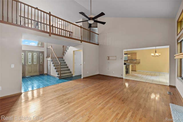 51992 Boland Rd, Chesterfield, MI 48047 - unfurnished living room with a high ceiling, light wood finished floors, a chandelier, a ceiling fan, and stairs