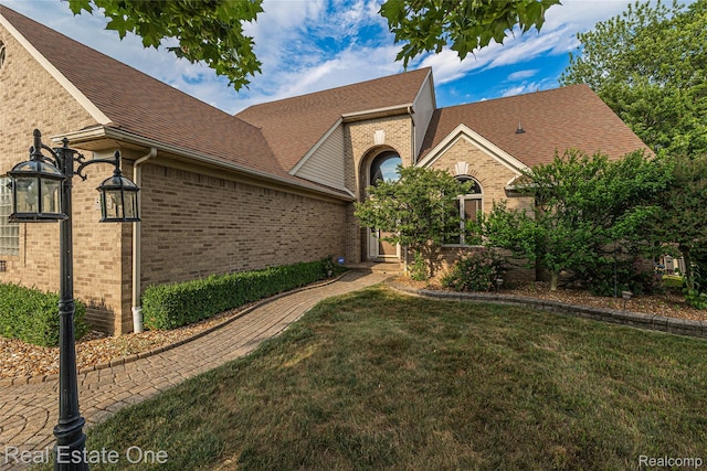 51992 Boland Rd, Chesterfield, MI 48047 - view of front facade with brick siding, a front yard, and roof with shingles
