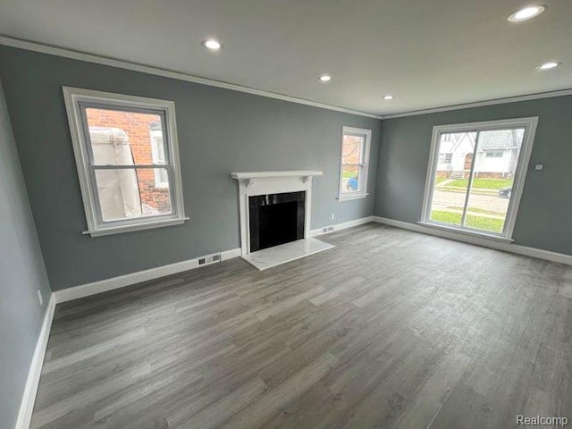 4651 Berkshire St, Detroit, MI 48224 - unfurnished living room with crown molding, wood finished floors, recessed lighting, plenty of natural light, and a high end fireplace
