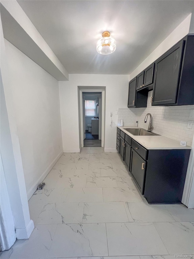 4651 Berkshire St, Detroit, MI 48224 - kitchen featuring light marble finish flooring, light countertops, tasteful backsplash, and dark cabinetry