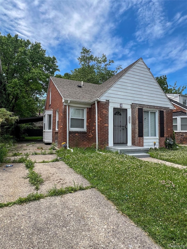 4651 Berkshire St, Detroit, MI 48224 - bungalow-style house featuring brick siding, a shingled roof, an attached carport, driveway, and a front lawn
