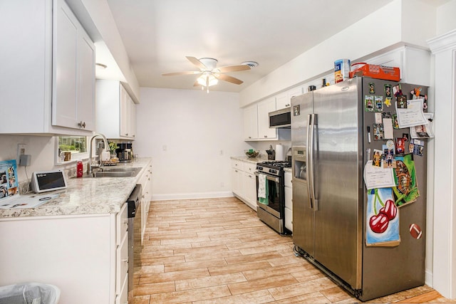 3341 Circle Dr, Saint Joseph, MI 49085 - kitchen with stainless steel appliances, a ceiling fan, white cabinetry, light wood finished floors, and light stone counters
