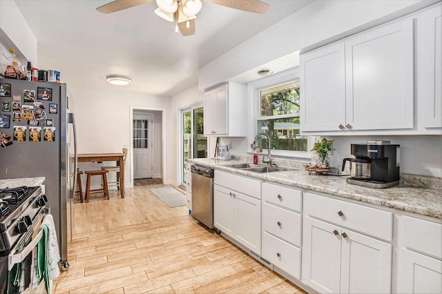 3341 Circle Dr, Saint Joseph, MI 49085 - kitchen with appliances with stainless steel finishes, a ceiling fan, light wood-style flooring, and white cabinetry