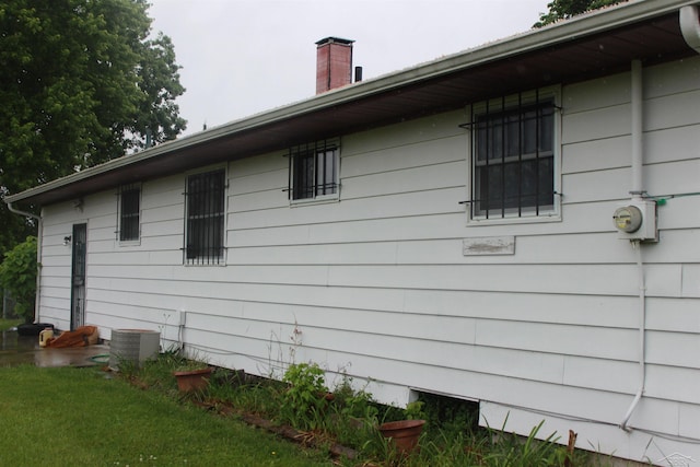 3211 S Arvin Dr, Saginaw, MI 48601 - view of side of property featuring a chimney and a central AC unit
