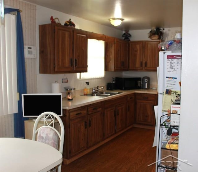 3211 S Arvin Dr, Saginaw, MI 48601 - kitchen with black microwave, light countertops, dark wood finished floors, and brown cabinets