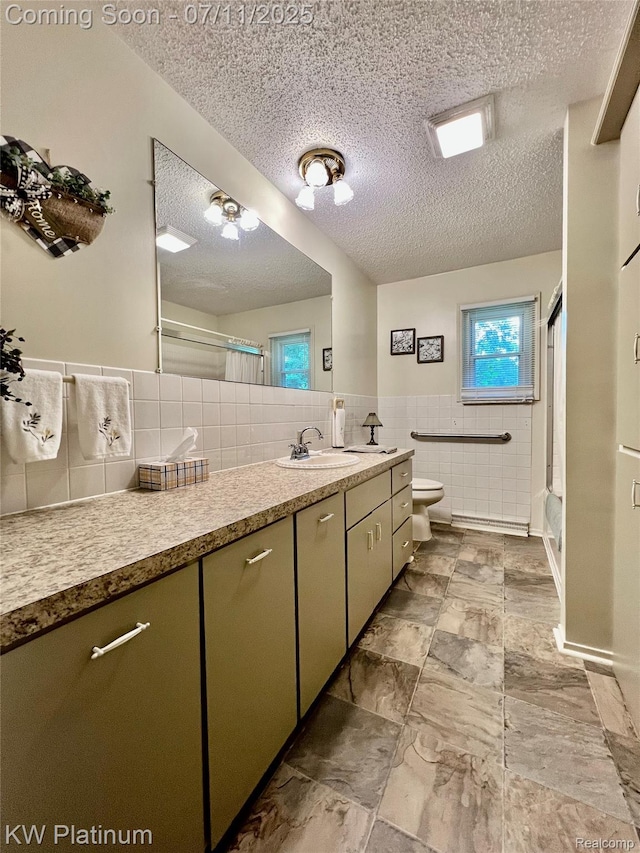 3775 Carrigan Rd, Fort Gratiot, MI 48059 - bathroom with tile walls, a textured ceiling, vanity, a shower stall, and a wainscoted wall