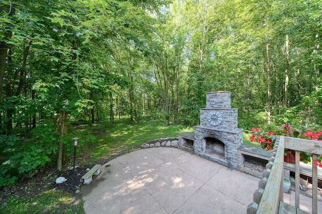 8395 Dalton Rd, Onsted, MI 49265 - view of patio featuring an outdoor stone fireplace and a forest view