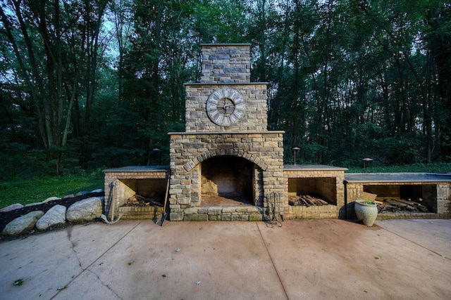 8395 Dalton Rd, Onsted, MI 49265 - view of patio / terrace featuring an outdoor fireplace and a wooded view