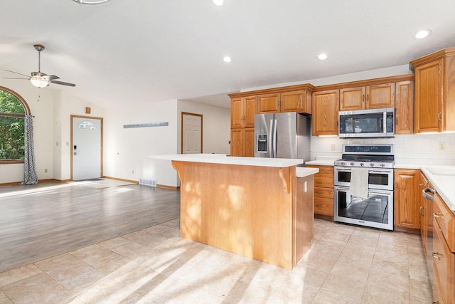 2240 Quincy Ave, Portage, MI 49024 - kitchen featuring stainless steel appliances, a ceiling fan, light countertops, a center island, and a kitchen breakfast bar