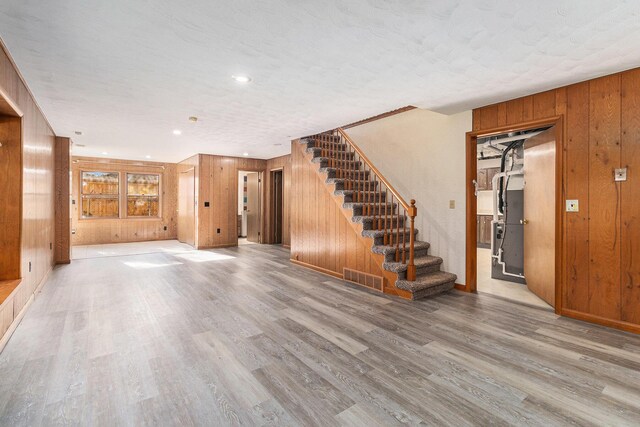 2240 Quincy Ave, Portage, MI 49024 - unfurnished living room featuring wooden walls, stairway, and wood finished floors