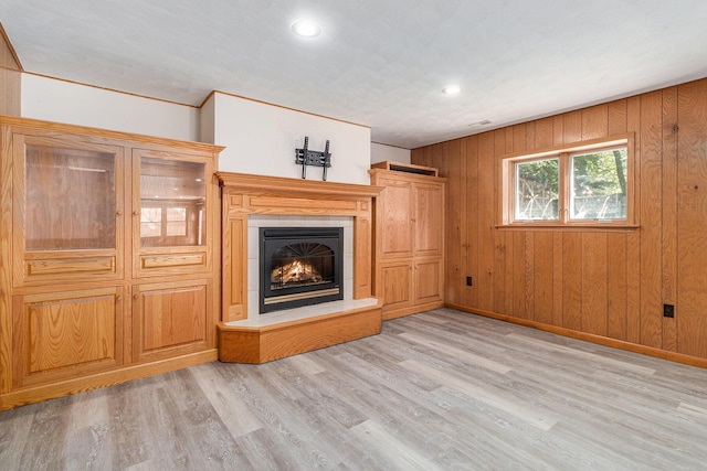 2240 Quincy Ave, Portage, MI 49024 - unfurnished living room with a warm lit fireplace, light wood-type flooring, wood walls, and recessed lighting