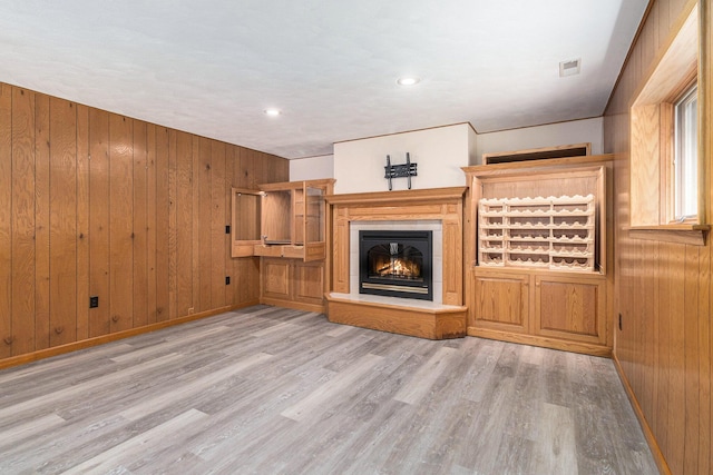 2240 Quincy Ave, Portage, MI 49024 - unfurnished living room featuring wood walls, wood finished floors, a glass covered fireplace, and recessed lighting