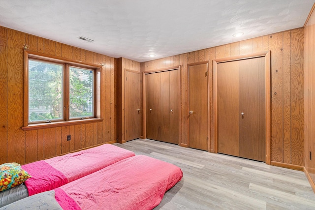 2240 Quincy Ave, Portage, MI 49024 - bedroom featuring multiple closets, wood finished floors, and wood walls