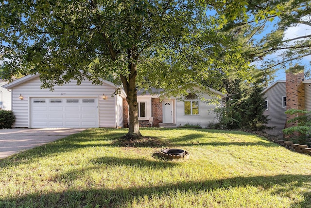 2240 Quincy Ave, Portage, MI 49024 - view of front of house featuring concrete driveway, a front lawn, an attached garage, and an outdoor fire pit