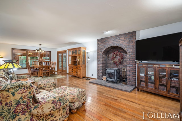 1214 Euna Vista Dr, Holland, MI 49423 - living room with wood-type flooring, a wood stove, and a chandelier