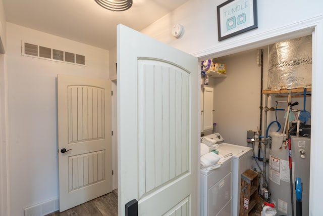 11901 187th Ave, Stanwood, MI 49346 - laundry area with washing machine and clothes dryer, water heater, wood finished floors, and cabinet space