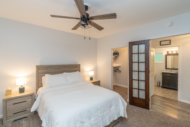 11901 187th Ave, Stanwood, MI 49346 - bedroom featuring a walk in closet, light carpet, a closet, ensuite bath, and a ceiling fan
