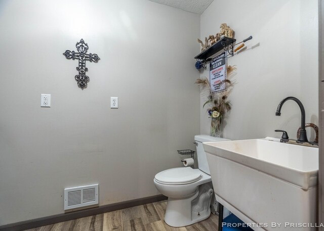 9265 Mulliken Rd, Mulliken, MI 48861 - half bathroom featuring wood finished floors and a textured ceiling