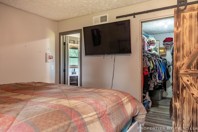 9265 Mulliken Rd, Mulliken, MI 48861 - carpeted bedroom with a spacious closet, a closet, a textured ceiling, and a barn door