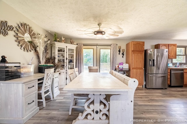 9265 Mulliken Rd, Mulliken, MI 48861 - dining space featuring wood finished floors, a textured ceiling, and french doors
