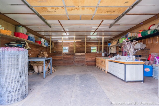 9265 Mulliken Rd, Mulliken, MI 48861 - miscellaneous room with a garage, concrete floors, and wooden walls