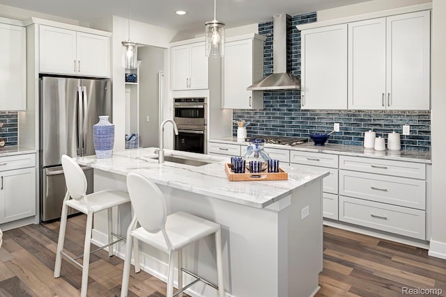 2348 Provencal Dr, Bloomfield Hills, MI 48382 - kitchen with wall chimney exhaust hood, appliances with stainless steel finishes, decorative backsplash, a center island with sink, and a breakfast bar area