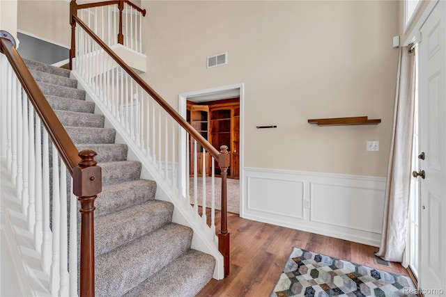6119 Amber Ln, Grand Blanc, MI 48439 - foyer featuring stairway, wood finished floors, a towering ceiling, and a wainscoted wall