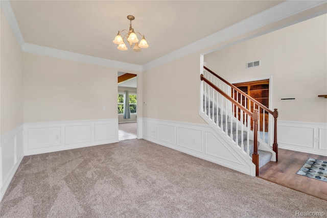 6119 Amber Ln, Grand Blanc, MI 48439 - carpeted spare room featuring ornamental molding, a chandelier, stairs, wainscoting, and a decorative wall