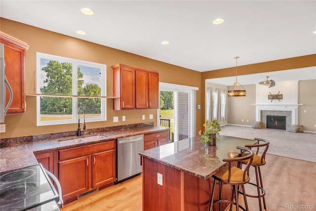 6119 Amber Ln, Grand Blanc, MI 48439 - kitchen with stainless steel dishwasher, open floor plan, range with electric cooktop, dark stone countertops, and a lit fireplace