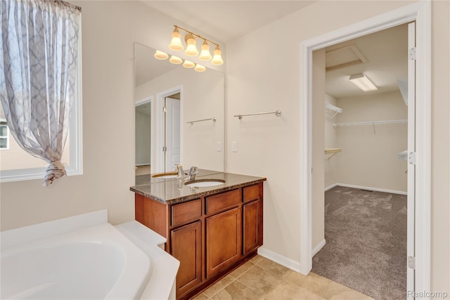 6119 Amber Ln, Grand Blanc, MI 48439 - bathroom featuring vanity, a bath, and a walk in closet