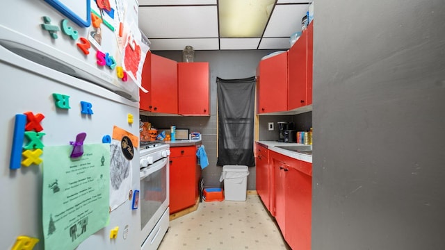 405 W 5th St, Evart, MI 49631 - kitchen with white appliances, red cabinetry, light floors, and yellow cabinets
