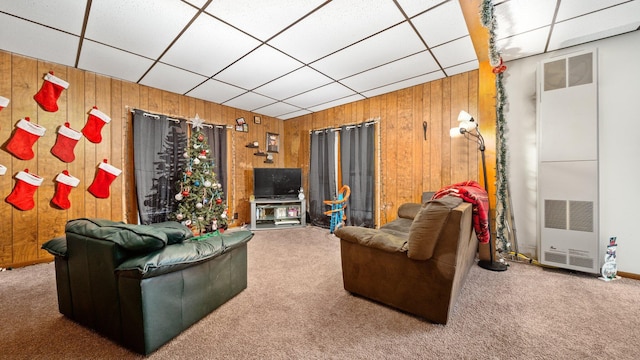 405 W 5th St, Evart, MI 49631 - carpeted living area with wood walls, a heating unit, and a paneled ceiling
