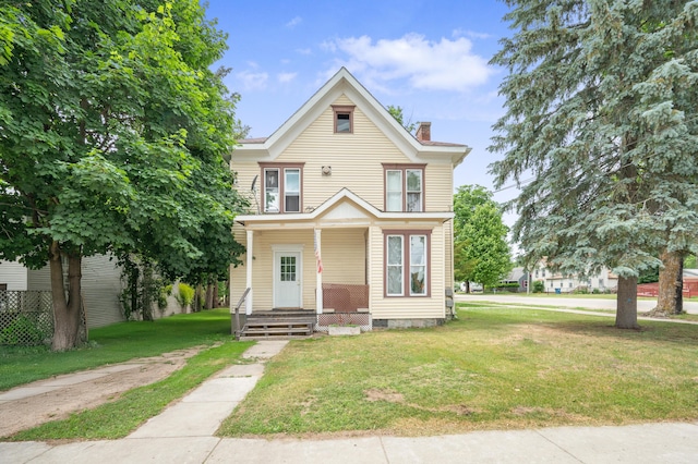 405 W 5th St, Evart, MI 49631 - view of front facade featuring a chimney, a porch, and a front lawn