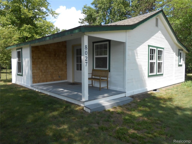8027 Lakeshore Rd, Lexington, MI 48450 - view of property exterior with a yard, covered porch, and a shingled roof