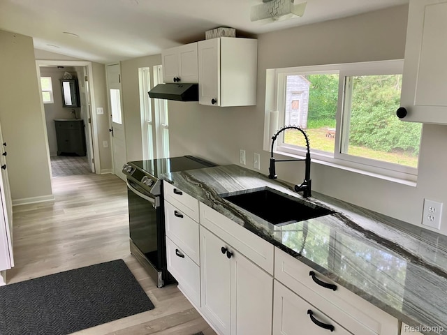 8027 Lakeshore Rd, Lexington, MI 48450 - kitchen with electric stove, under cabinet range hood, dark stone counters, white cabinetry, and light wood-style floors