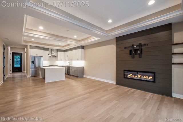 722 E Parent Ave, Royal Oak, MI 48067 - kitchen with appliances with stainless steel finishes, a raised ceiling, wall chimney exhaust hood, open floor plan, and a center island