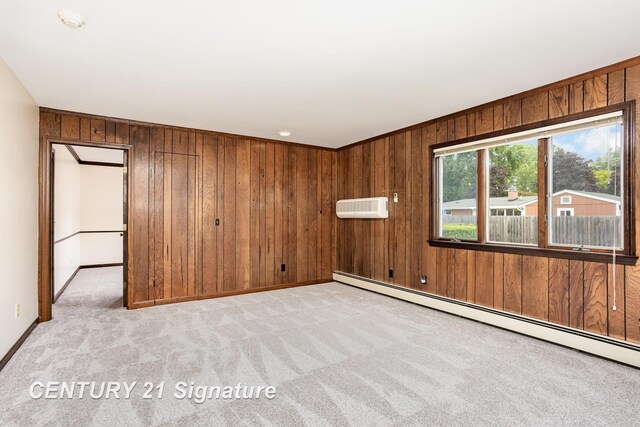 2936 Reppuhn Dr, Saginaw, MI 48603 - empty room featuring a baseboard heating unit, light colored carpet, wooden walls, an AC wall unit, and a smoke detector