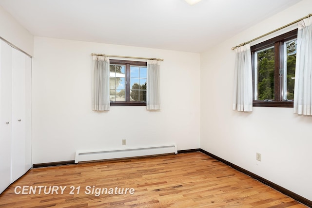2936 Reppuhn Dr, Saginaw, MI 48603 - unfurnished bedroom featuring baseboard heating, multiple windows, light wood finished floors, and a closet