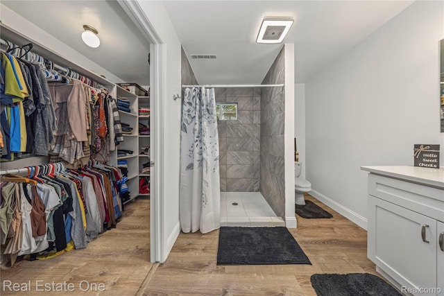 7241 Richardson Rd, West Bloomfield, MI 48323 - full bathroom with vanity, a shower stall, wood finished floors, and a walk in closet