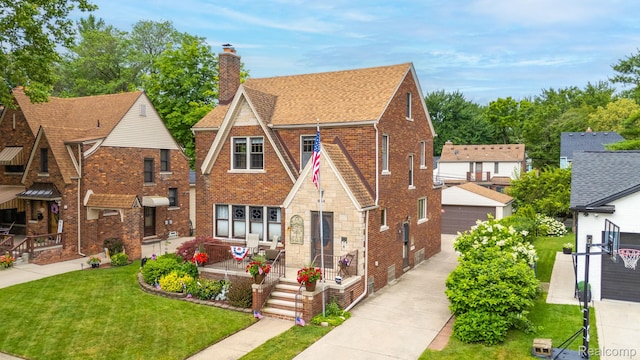 648 S Highland St, Dearborn, MI 48124 - tudor home featuring a chimney, brick siding, a front yard, and roof with shingles