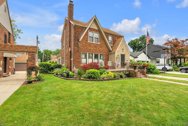 648 S Highland St, Dearborn, MI 48124 - tudor home with a chimney, a front lawn, and brick siding