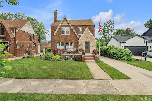 648 S Highland St, Dearborn, MI 48124 - tudor-style house featuring a chimney, brick siding, and a front yard