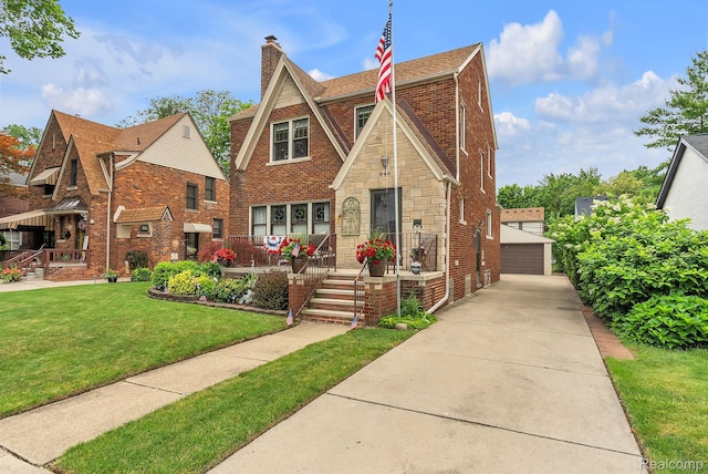 648 S Highland St, Dearborn, MI 48124 - english style home featuring brick siding, an outdoor structure, a front lawn, a garage, and a chimney