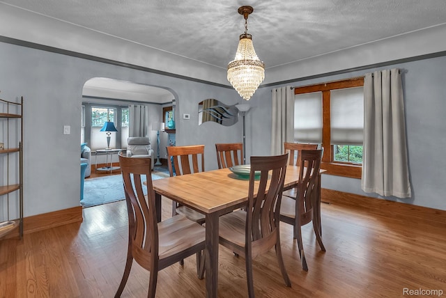 648 S Highland St, Dearborn, MI 48124 - dining area featuring arched walkways, wood finished floors, and a chandelier