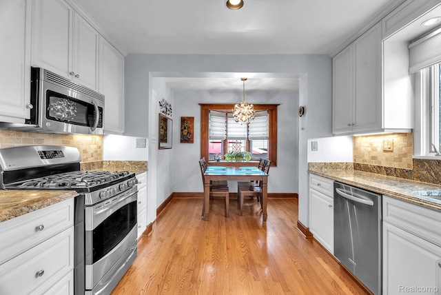 648 S Highland St, Dearborn, MI 48124 - kitchen featuring stainless steel appliances, a chandelier, white cabinets, and light wood finished floors