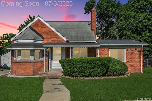 65 Martin Luther King Jr Blvd N, Pontiac, MI 48342 - view of front of property featuring a front yard, a chimney, brick siding, and a shingled roof