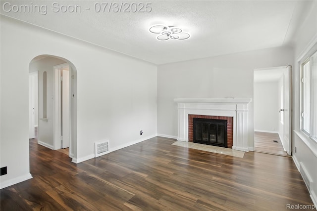 65 Martin Luther King Jr Blvd N, Pontiac, MI 48342 - unfurnished living room featuring a fireplace, wood finished floors, a textured ceiling, and arched walkways